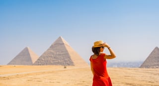 A Tourist Girl In A Red Dress Looking At The Pyramids Of Giza The Oldest Funerary Monument