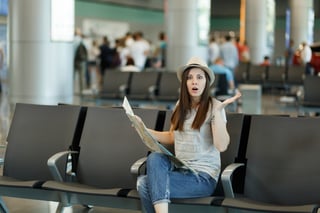 Young Shocked Traveler Tourist Woman Holding Paper Map Search Route Spreading Hands Wait In Lobby